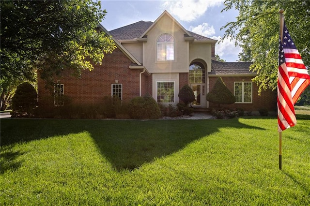 6501 N National Dr, Parkville, MO 64152 - traditional home featuring a front lawn, stucco siding, brick siding, and roof with shingles