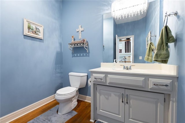 6501 N National Dr, Parkville, MO 64152 - bathroom with wood finished floors, toilet, vanity, and baseboards