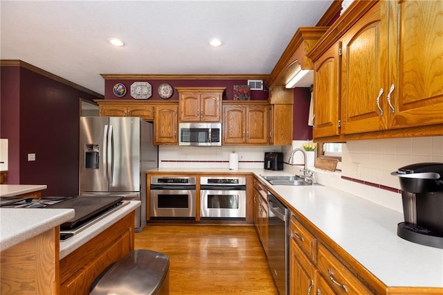 6501 N National Dr, Parkville, MO 64152 - kitchen with stainless steel appliances, a sink, light countertops, brown cabinetry, and decorative backsplash