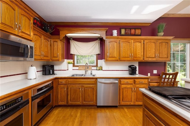 6501 N National Dr, Parkville, MO 64152 - kitchen featuring stainless steel appliances, a sink, brown cabinetry, and healthy amount of natural light