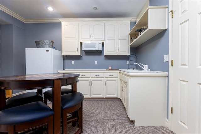 6501 N National Dr, Parkville, MO 64152 - kitchen with carpet floors, white appliances, white cabinetry, ornamental molding, and recessed lighting