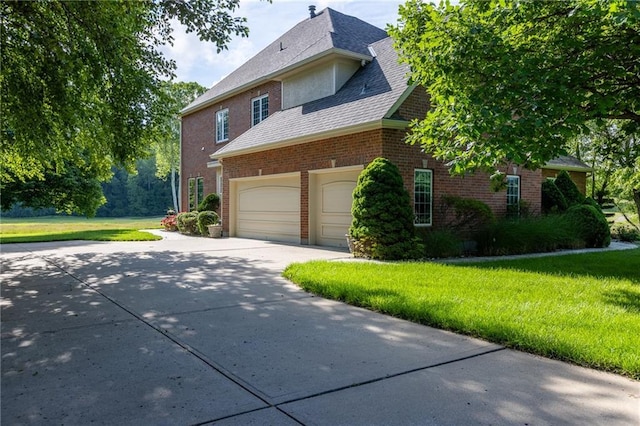 6501 N National Dr, Parkville, MO 64152 - view of front of house featuring concrete driveway, a front lawn, brick siding, and a garage