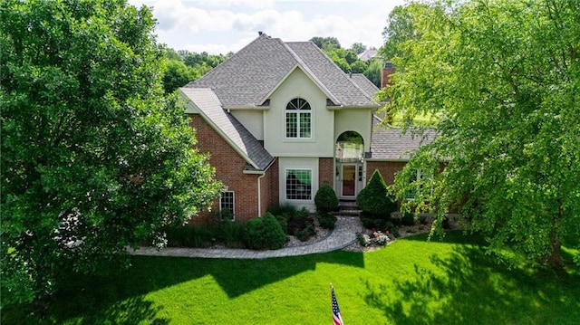 6501 N National Dr, Parkville, MO 64152 - traditional-style home featuring brick siding, a front yard, stucco siding, a shingled roof, and a chimney