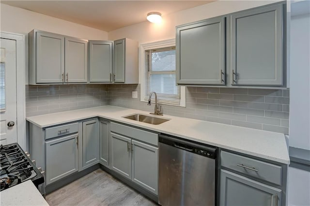 6117 Harrison St, Kansas City, MO 64110 - kitchen featuring stainless steel dishwasher, gray cabinetry, a sink, and light countertops