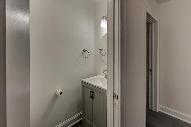 6117 Harrison St, Kansas City, MO 64110 - bathroom with vanity, baseboards, and wood finished floors