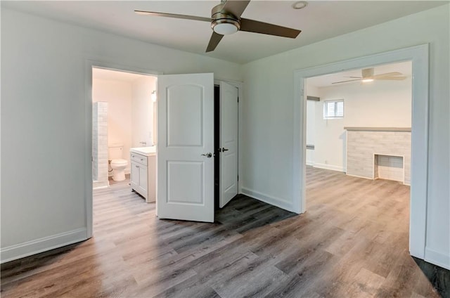 6117 Harrison St, Kansas City, MO 64110 - unfurnished bedroom featuring wood finished floors, baseboards, and ensuite bath