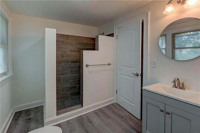 6117 Harrison St, Kansas City, MO 64110 - bathroom featuring wood finished floors, a walk in shower, vanity, and healthy amount of natural light