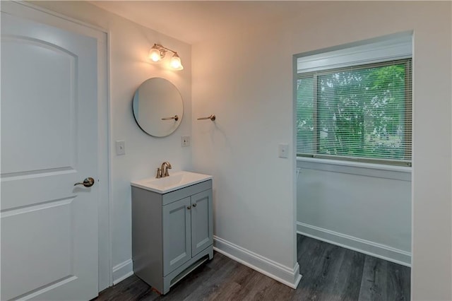 6117 Harrison St, Kansas City, MO 64110 - bathroom with wood finished floors, vanity, and baseboards