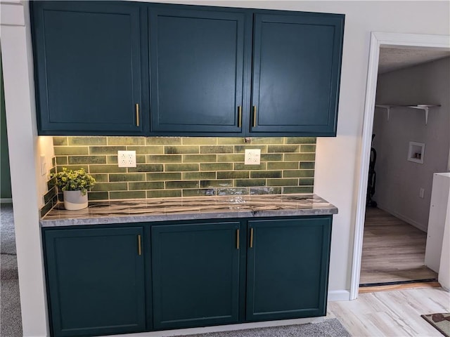 203 W 4th St, Holden, MO 64040 - detailed view of blue cabinetry, light wood-style floors, backsplash, and baseboards