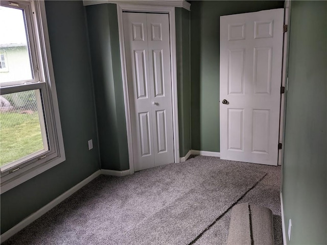 203 W 4th St, Holden, MO 64040 - unfurnished bedroom with multiple windows, a closet, carpet, and baseboards