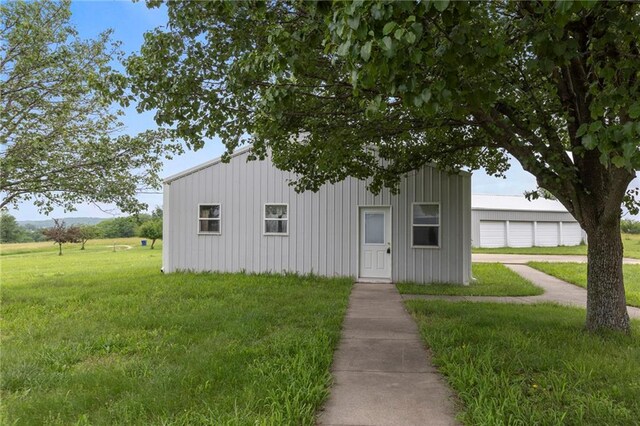 25549 Chieftain Rd, Lawrence, KS 66044 - view of front of house featuring a front lawn, a garage, and board and batten siding