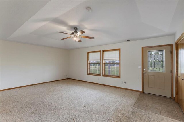 25549 Chieftain Rd, Lawrence, KS 66044 - foyer entrance featuring healthy amount of natural light, a ceiling fan, light carpet, and a tray ceiling