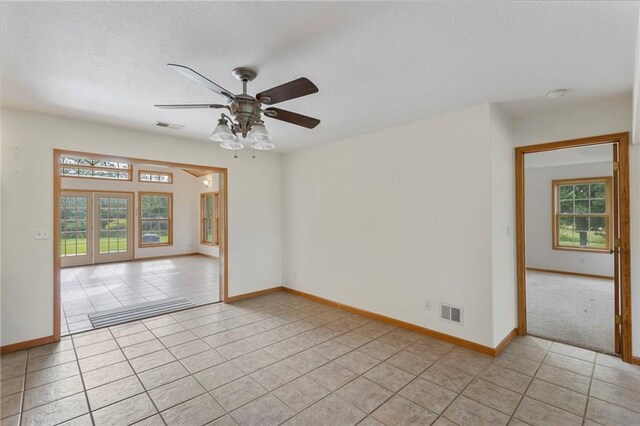 25549 Chieftain Rd, Lawrence, KS 66044 - empty room featuring a textured ceiling, light tile patterned floors, baseboards, and ceiling fan