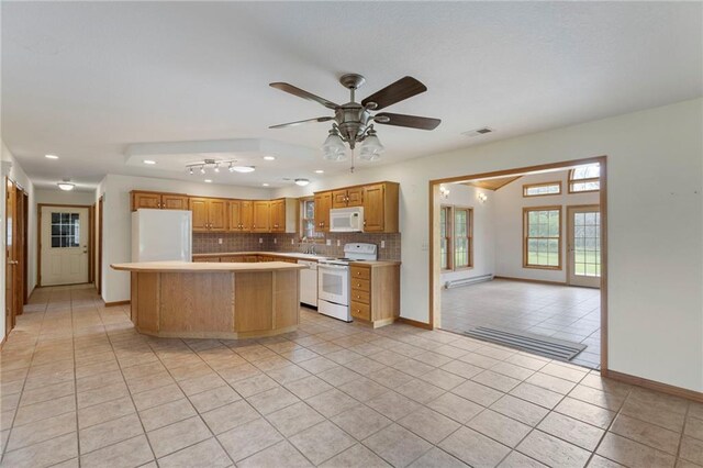 25549 Chieftain Rd, Lawrence, KS 66044 - kitchen featuring white appliances, light tile patterned flooring, light countertops, tasteful backsplash, and a kitchen island