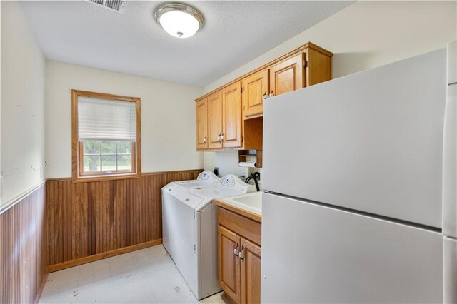 25549 Chieftain Rd, Lawrence, KS 66044 - laundry area with cabinet space, wainscoting, washer and clothes dryer, and wood walls