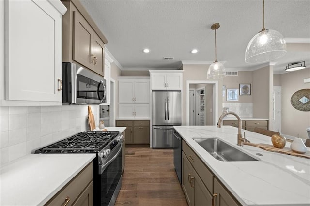 8215 Aurora St, Lenexa, KS 66220 - kitchen featuring appliances with stainless steel finishes, a sink, ornamental molding, dark wood finished floors, and decorative light fixtures