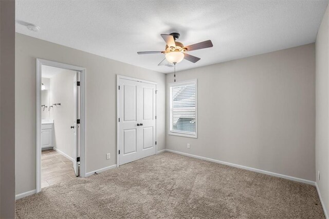 9154 Shady Bend Rd, Lenexa, KS 66227 - unfurnished bedroom with carpet floors, a closet, a textured ceiling, ensuite bathroom, and ceiling fan