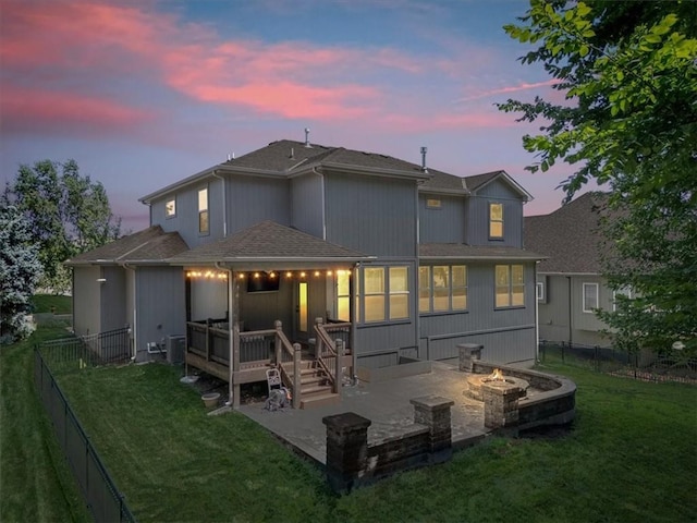 9154 Shady Bend Rd, Lenexa, KS 66227 - back of property at dusk featuring a fire pit, a patio area, roof with shingles, a fenced backyard, and a wooden deck