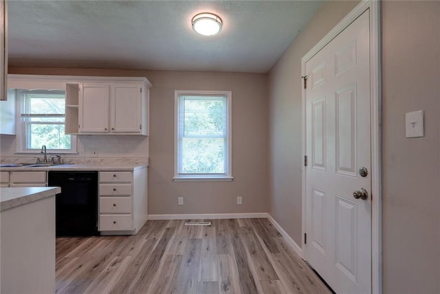 3512 Harvard Ave, Independence, MO 64052 - kitchen featuring black dishwasher, light countertops, white cabinetry, and light wood finished floors
