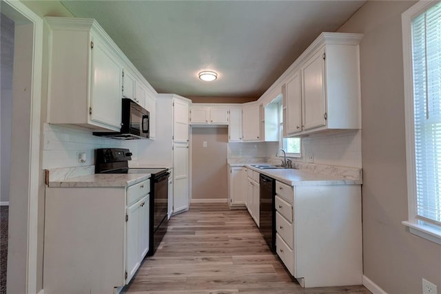 3512 Harvard Ave, Independence, MO 64052 - kitchen featuring black appliances, tasteful backsplash, light wood-type flooring, white cabinets, and light countertops
