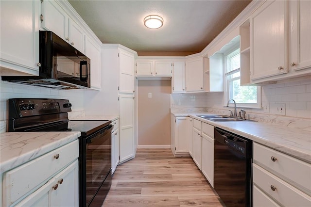 3512 Harvard Ave, Independence, MO 64052 - kitchen with black appliances, white cabinetry, light wood finished floors, and decorative backsplash