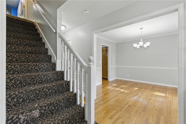 11409 Riley St, Overland Park, KS 66210 - staircase featuring wood finished floors, a chandelier, and ornamental molding