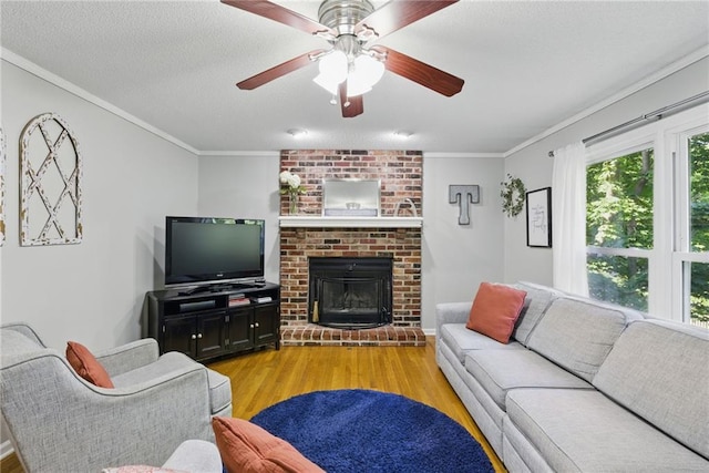 11409 Riley St, Overland Park, KS 66210 - living room featuring light wood finished floors, crown molding, a ceiling fan, and a brick fireplace