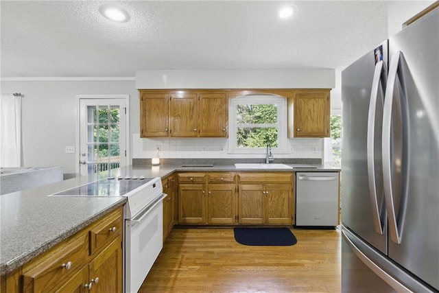 11409 Riley St, Overland Park, KS 66210 - kitchen featuring appliances with stainless steel finishes, backsplash, brown cabinetry, a textured ceiling, and recessed lighting