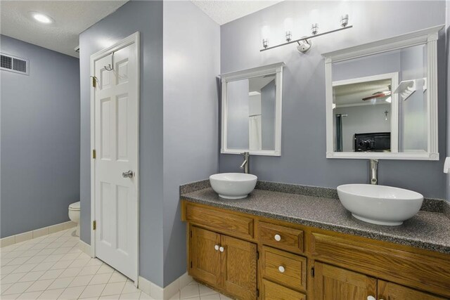 11409 Riley St, Overland Park, KS 66210 - bathroom featuring double vanity, a textured ceiling, and tile patterned flooring