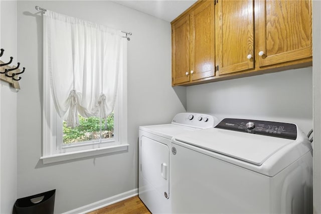 11409 Riley St, Overland Park, KS 66210 - laundry room featuring washing machine and clothes dryer, cabinet space, and wood finished floors