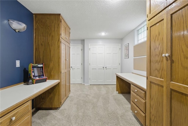 11409 Riley St, Overland Park, KS 66210 - home office featuring built in desk, light colored carpet, and a textured ceiling