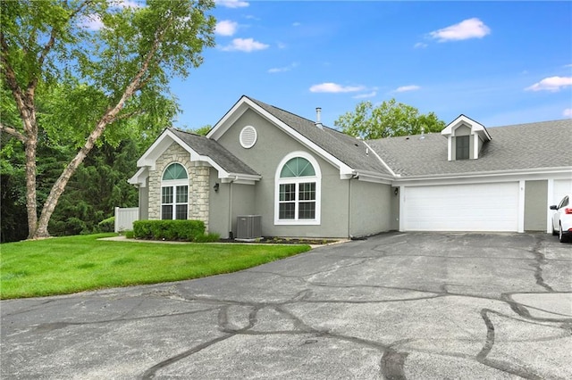7226 Meadow View St, Shawnee, KS 66227 - ranch-style home featuring central air condition unit, driveway, an attached garage, stucco siding, and a front yard
