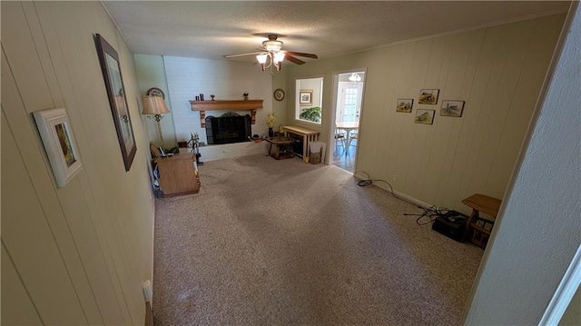 2006 Colonial Dr, Pittsburg, KS 66762 - carpeted living area featuring ceiling fan, a brick fireplace, a textured ceiling, and ornamental molding