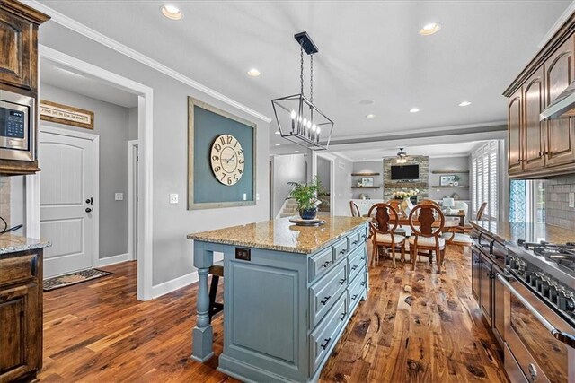 17746 W 165th Pl, Olathe, KS 66062 - kitchen with crown molding, dark wood-style flooring, appliances with stainless steel finishes, recessed lighting, and light stone countertops