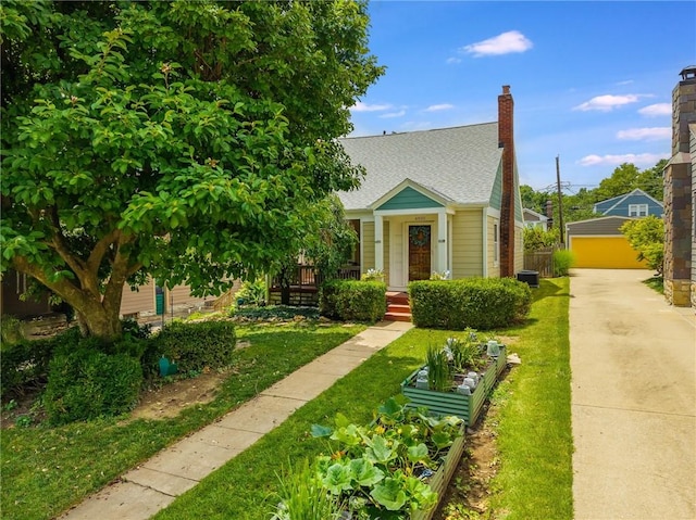 4930 Holly St, Kansas City, MO 64112 - view of front of home with roof with shingles, a vegetable garden, and a front yard