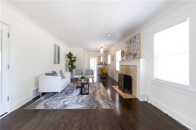 4930 Holly St, Kansas City, MO 64112 - living room featuring wood finished floors, ornamental molding, plenty of natural light, and a high end fireplace