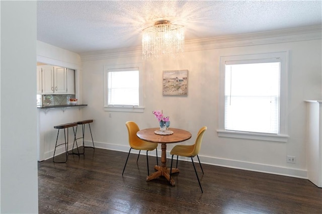 4930 Holly St, Kansas City, MO 64112 - dining room featuring a chandelier, dark wood-type flooring, a textured ceiling, and crown molding