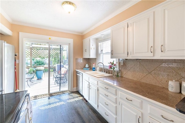 4930 Holly St, Kansas City, MO 64112 - kitchen featuring appliances with stainless steel finishes, tile countertops, plenty of natural light, ornamental molding, and decorative backsplash