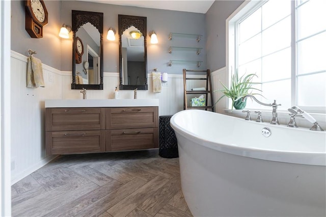 4930 Holly St, Kansas City, MO 64112 - bathroom with double vanity, a soaking tub, and a wainscoted wall
