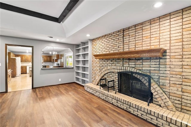 2207 N 154th Ter, Basehor, KS 66007 - unfurnished living room with a fireplace, recessed lighting, wood finished floors, a chandelier, and built in shelves