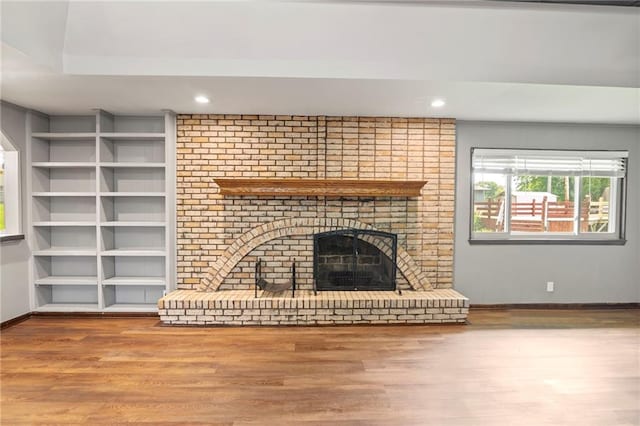 2207 N 154th Ter, Basehor, KS 66007 - unfurnished living room featuring wood finished floors, built in shelves, a fireplace, and recessed lighting