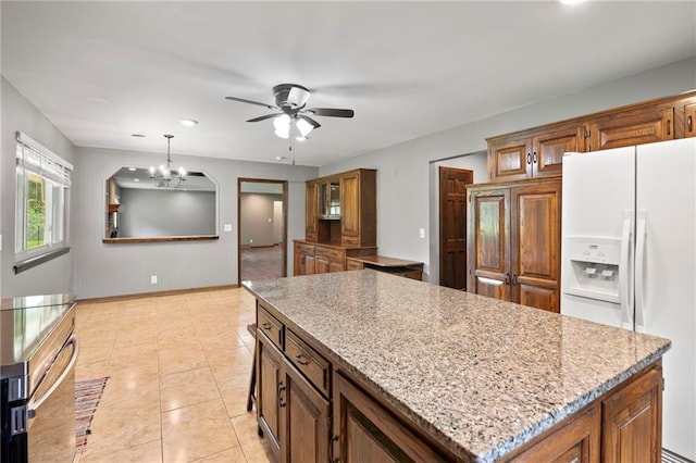2207 N 154th Ter, Basehor, KS 66007 - kitchen featuring white fridge with ice dispenser, ceiling fan, a kitchen island, a chandelier, and brown cabinetry