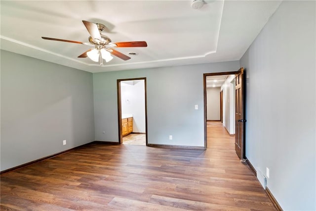 2207 N 154th Ter, Basehor, KS 66007 - unfurnished bedroom featuring wood finished floors, connected bathroom, and a ceiling fan