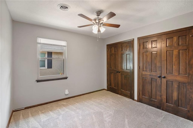 2207 N 154th Ter, Basehor, KS 66007 - unfurnished bedroom featuring carpet, two closets, and ceiling fan