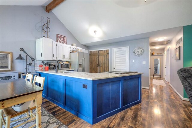 5603 Cody St, Shawnee, KS 66203 - kitchen with stainless steel fridge, a peninsula, dark wood-style floors, white cabinets, and light stone counters