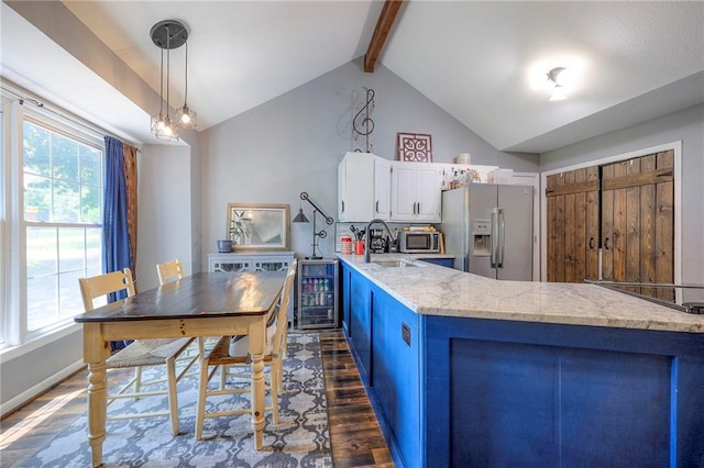 5603 Cody St, Shawnee, KS 66203 - kitchen featuring stainless steel fridge, dark wood-type flooring, wine cooler, white cabinets, and hanging light fixtures