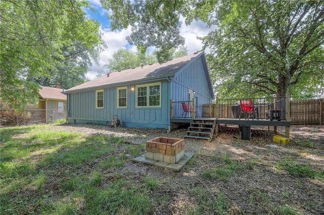 5603 Cody St, Shawnee, KS 66203 - back of property with board and batten siding, a wooden deck, a fenced backyard, and roof with shingles