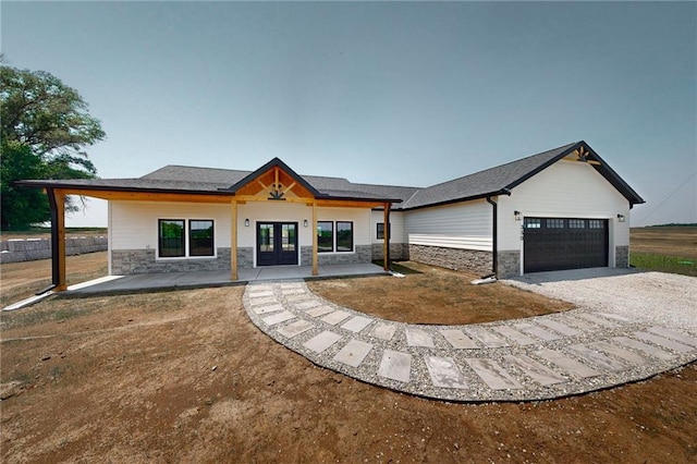 350 NW 1201st Rd, Holden, MO 64040 - modern farmhouse with french doors, stone siding, driveway, and an attached garage