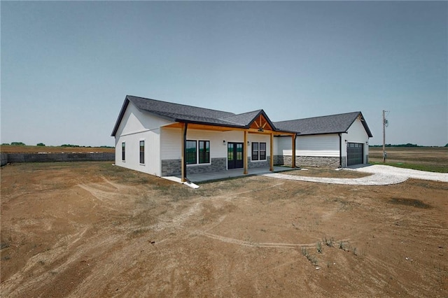 350 NW 1201st Rd, Holden, MO 64040 - view of front of house with dirt driveway, stone siding, and a garage