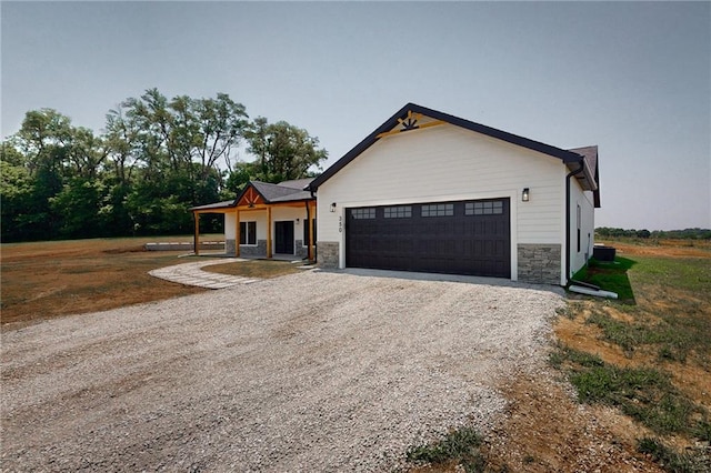350 NW 1201st Rd, Holden, MO 64040 - modern farmhouse style home with stone siding, gravel driveway, and a garage
